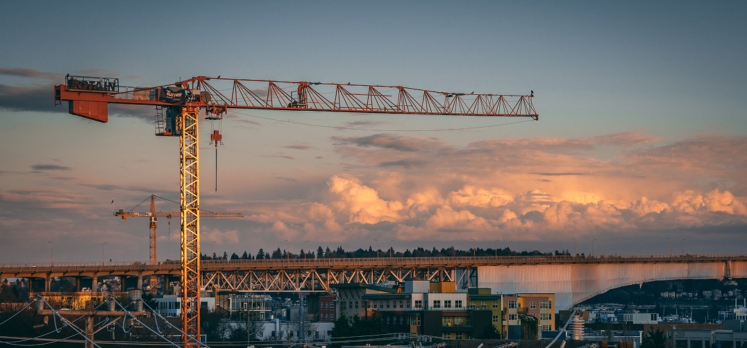 Construction cranes at sunset